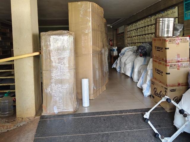Wrapped cupboards, cartons and bags stacked in a building lobby ready for loading